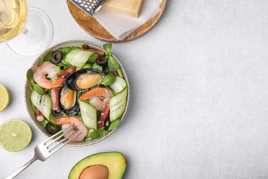 Bowl of delicious salad with seafood on light grey table, flat lay. Space for text