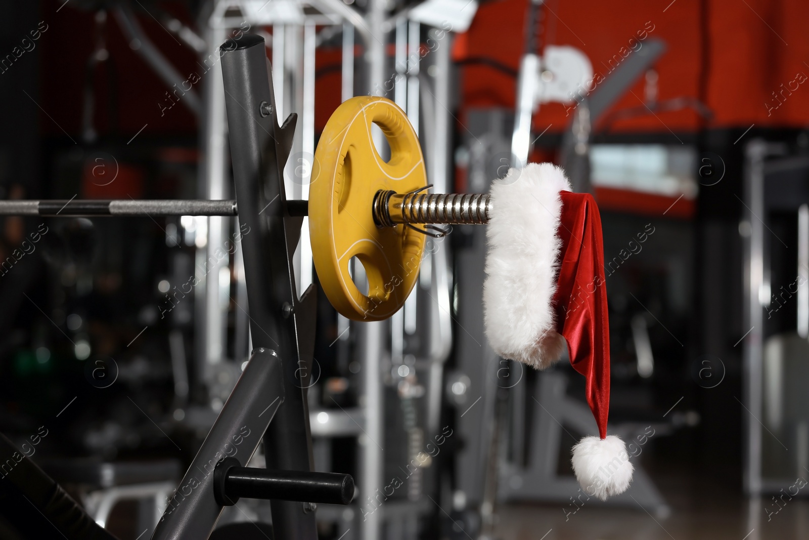 Photo of Santa Claus hat on barbell in gym