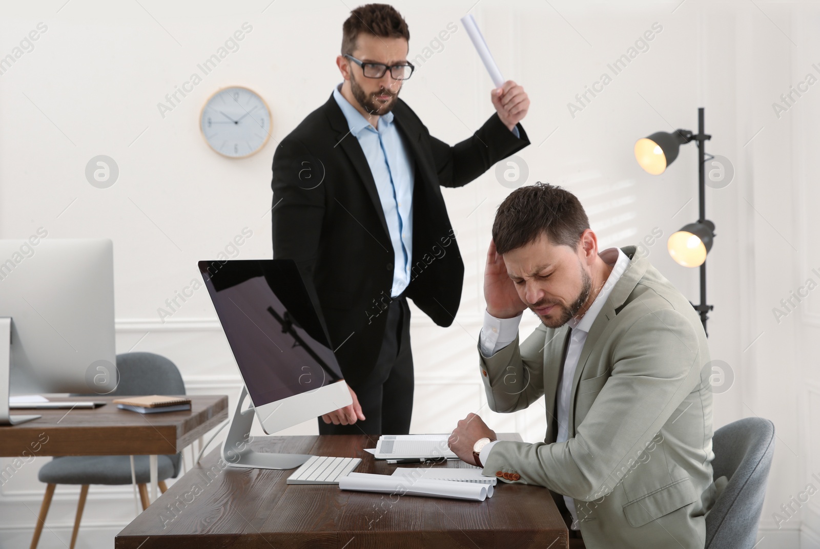 Photo of Boss scolding employee in office. Toxic work environment