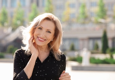 Portrait of happy mature woman on city street