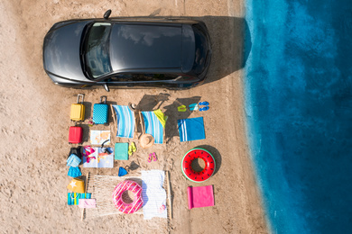 Image of Car and beach accessories on sand near river, aerial view. Summer trip