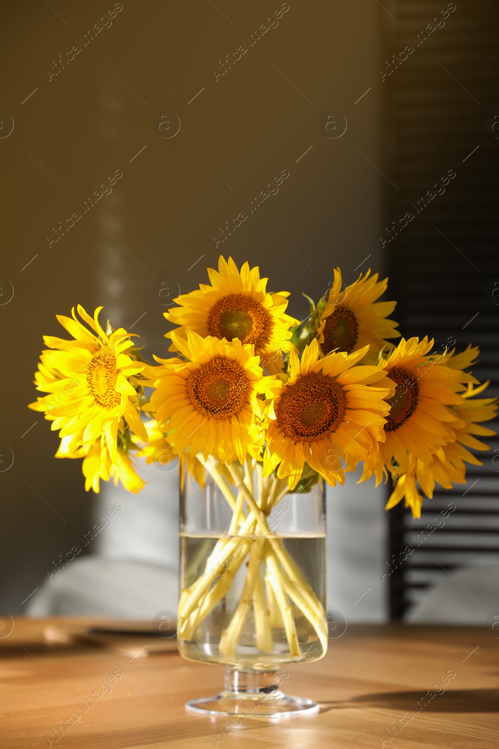 Photo of Bouquet of beautiful sunflowers on table in room