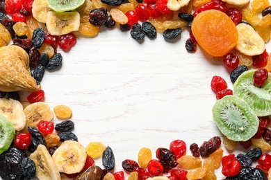Photo of Frame made of different dried fruits on wooden background, flat lay with space for text. Healthy lifestyle