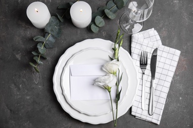 Elegant festive table setting on dark grey background, flat lay