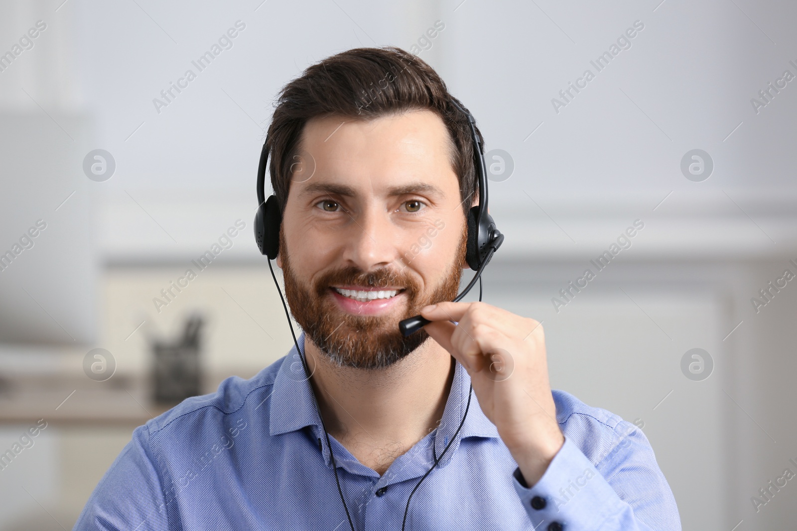 Photo of Hotline operator with headset working in office