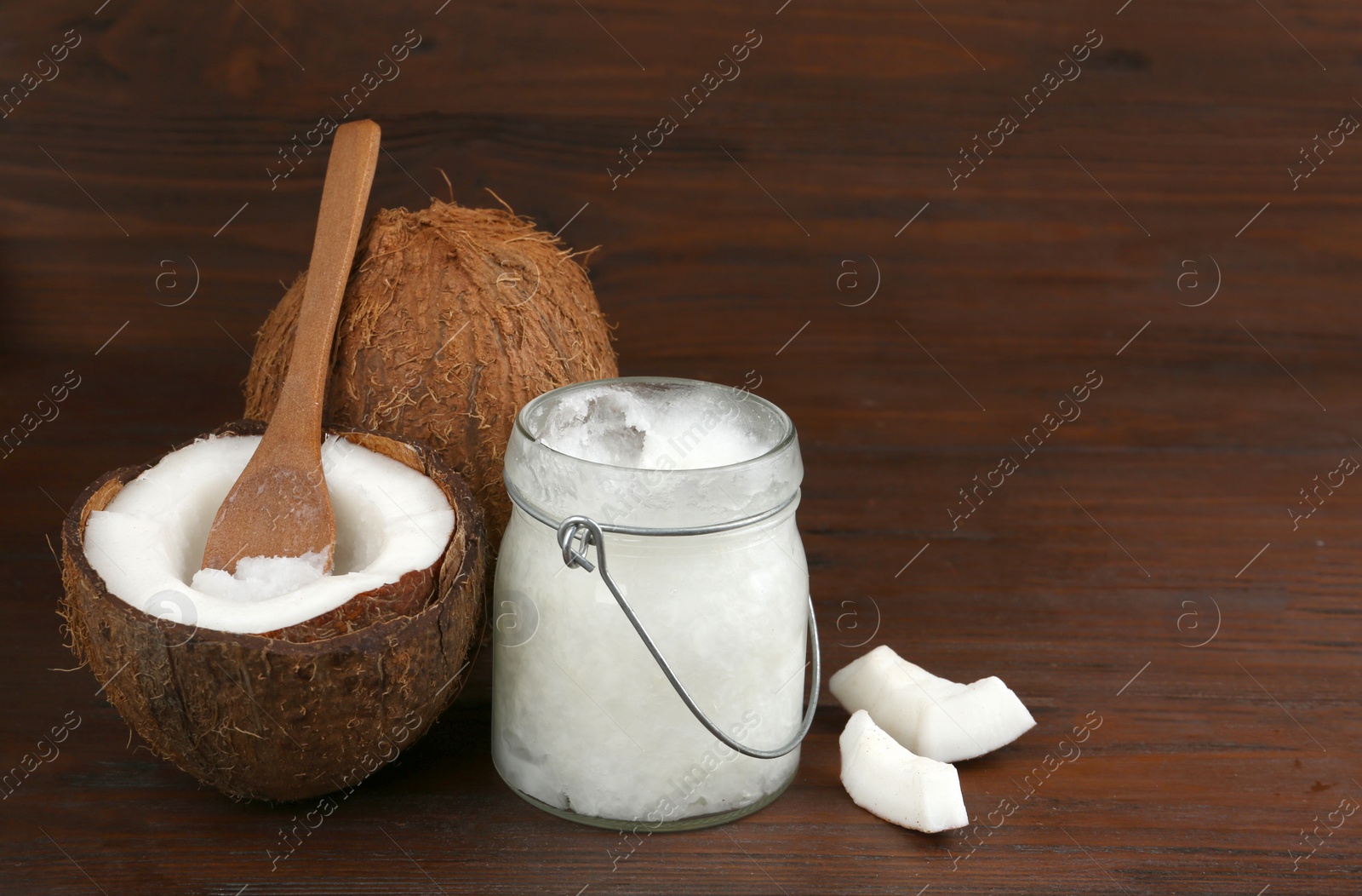 Photo of Composition with organic coconut oil on wooden table. Healthy cooking