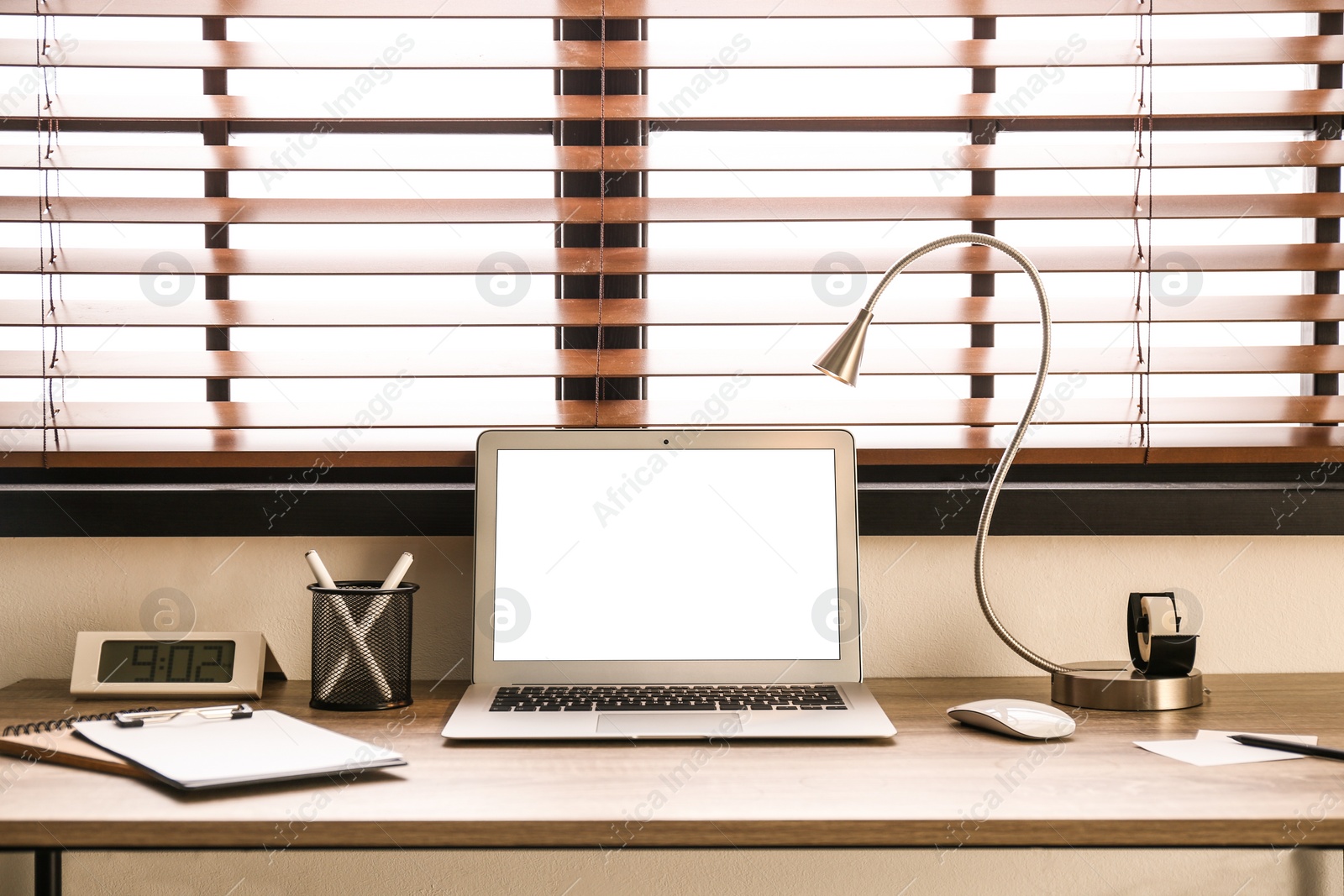 Photo of Modern laptop on table in office. Comfortable workplace