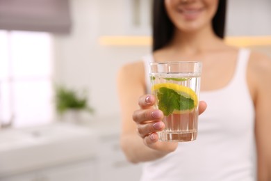 Photo of Young woman with glass of fresh lemonade at home, closeup