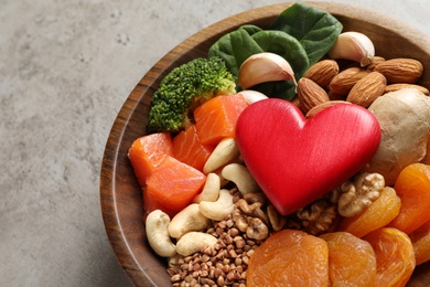 Photo of Bowl with heart-healthy products on grey background, closeup