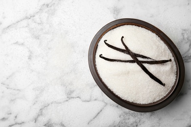 Photo of Bowl of aromatic vanilla sugar and sticks on light background