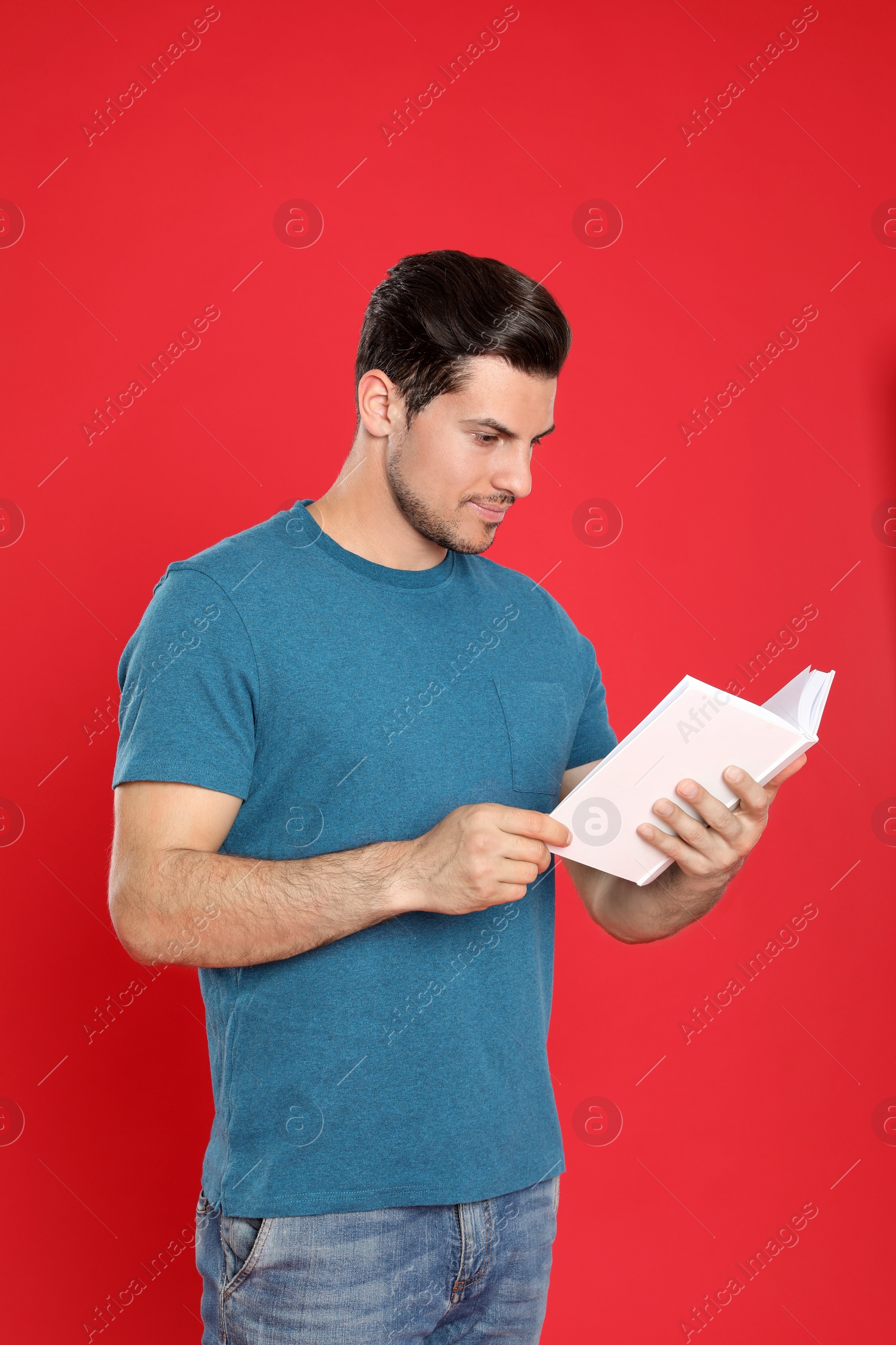 Photo of Handsome man reading book on color background