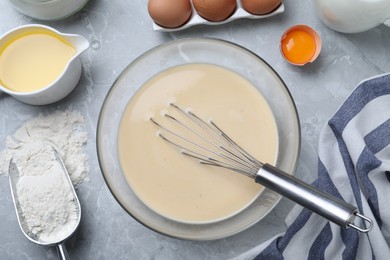 Photo of Batter for thin pancakes and products on light grey table, flat lay