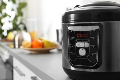 Photo of Modern multi cooker on table, closeup. Space for text