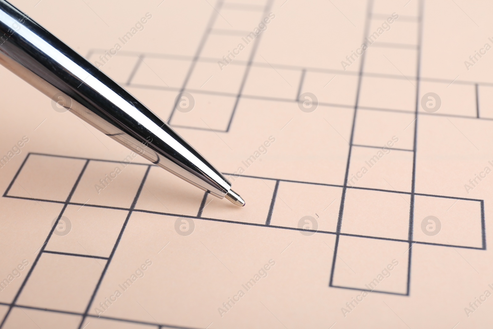 Photo of Pencil and blank crossword, closeup. Space for text
