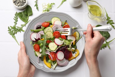 Photo of Balanced diet and vegetarian foods. Woman eating dinner at white table, top view