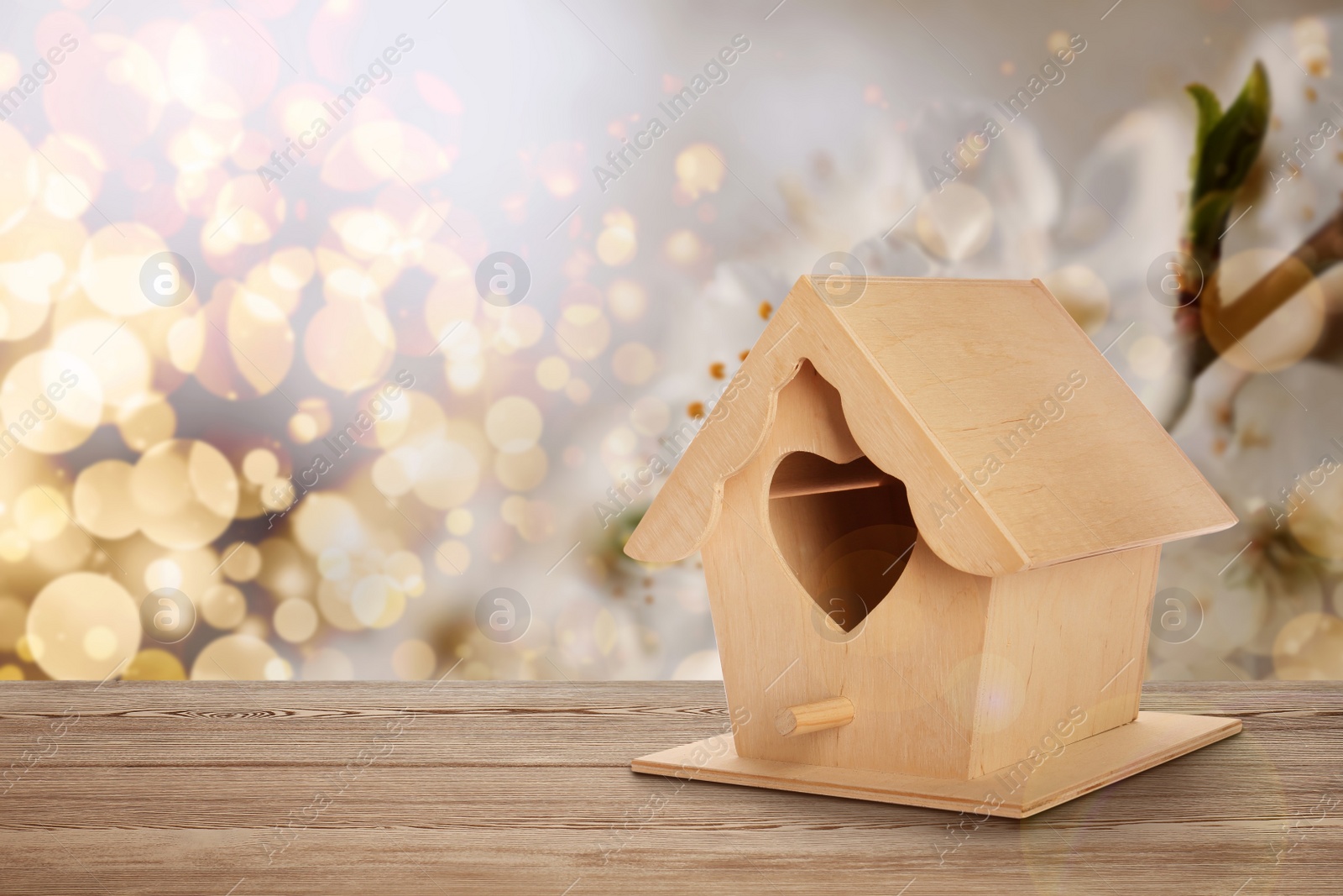 Image of Beautiful bird house on wooden table outdoors, space for text