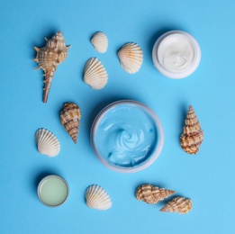 Photo of Flat lay composition with jars of body cream on light blue background