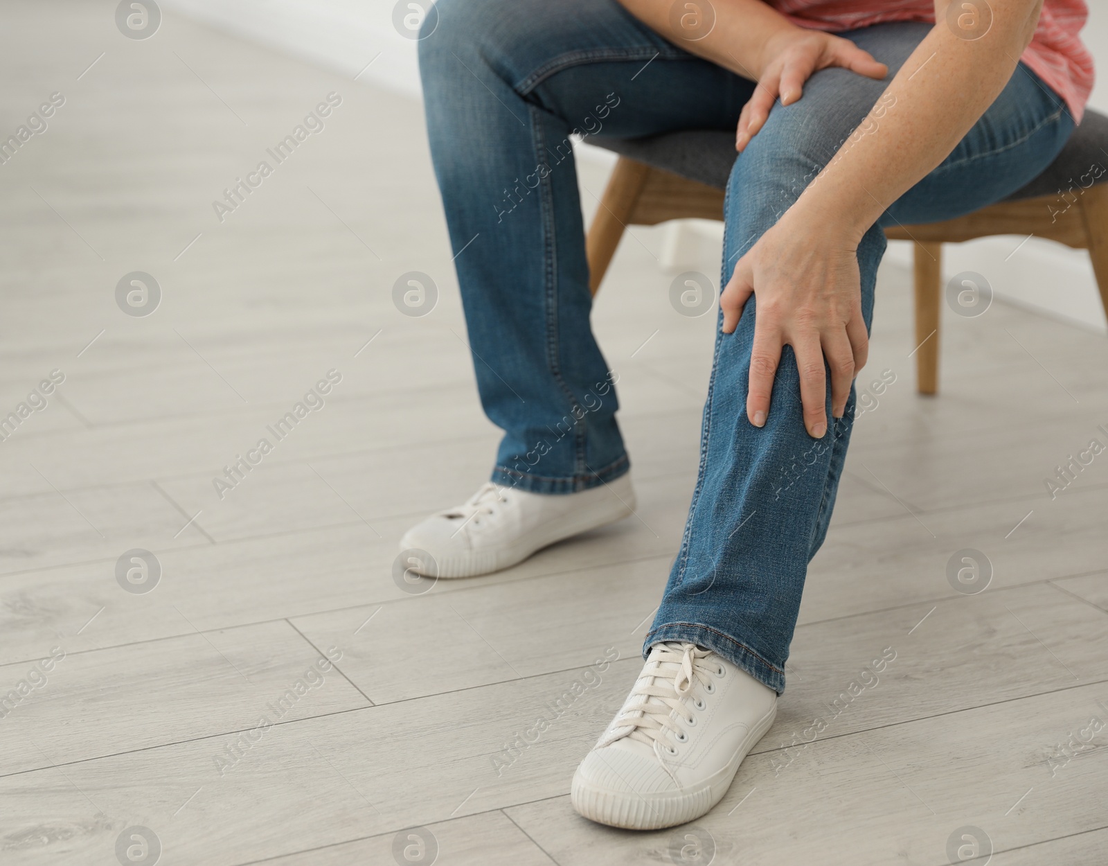 Photo of Mature woman suffering from leg pain at home, closeup. Space for text