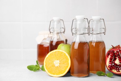 Photo of Tasty kombucha, fresh fruits and mint on white table