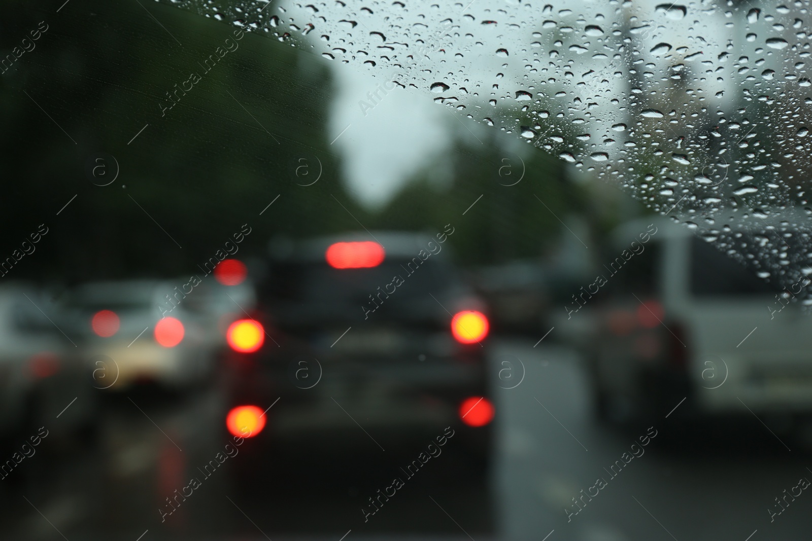 Photo of Blurred view of road through wet car window. Rainy weather