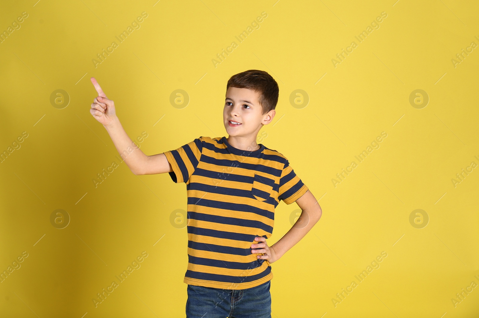 Photo of Portrait of cute little boy on yellow background