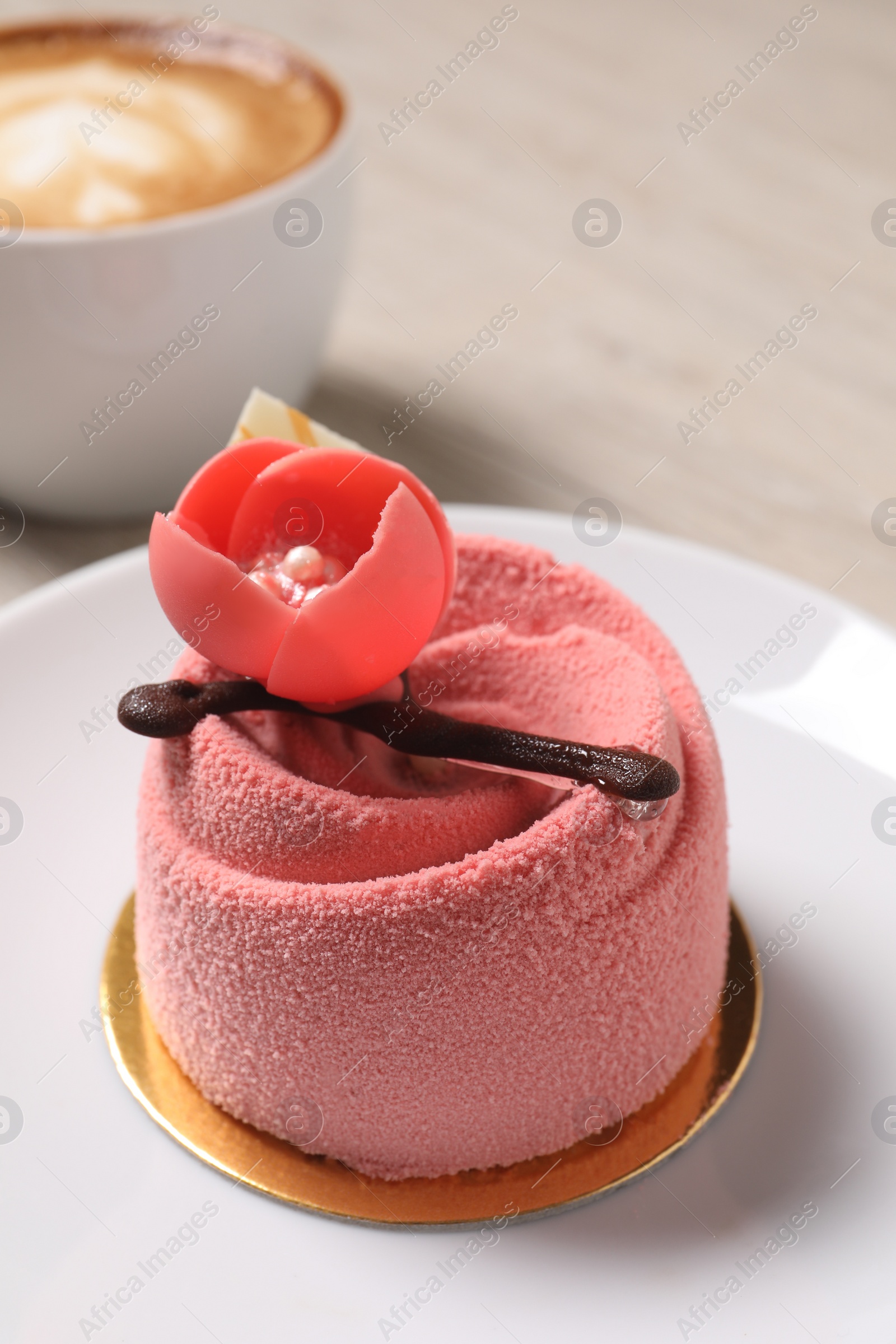 Photo of Delicious mousse cake with floral decor on plate, closeup