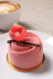 Photo of Delicious mousse cake with floral decor on plate, closeup