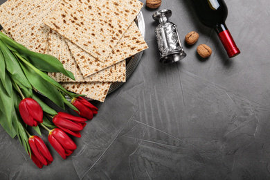 Photo of Flat lay composition with matzos on dark background, space for text. Passover (Pesach) celebration