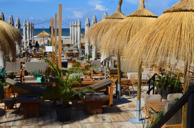 Beautiful straw beach umbrellas in modern outdoors cafe