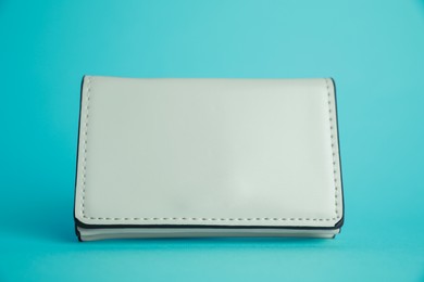 Photo of Stylish leather purse on light blue background