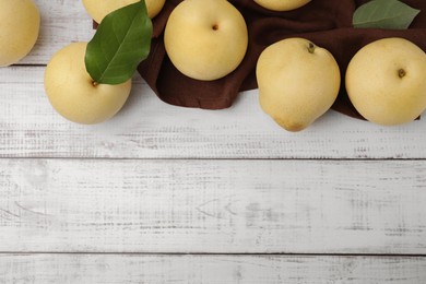Photo of Delicious apple pears on white wooden table, flat lay. Space for text