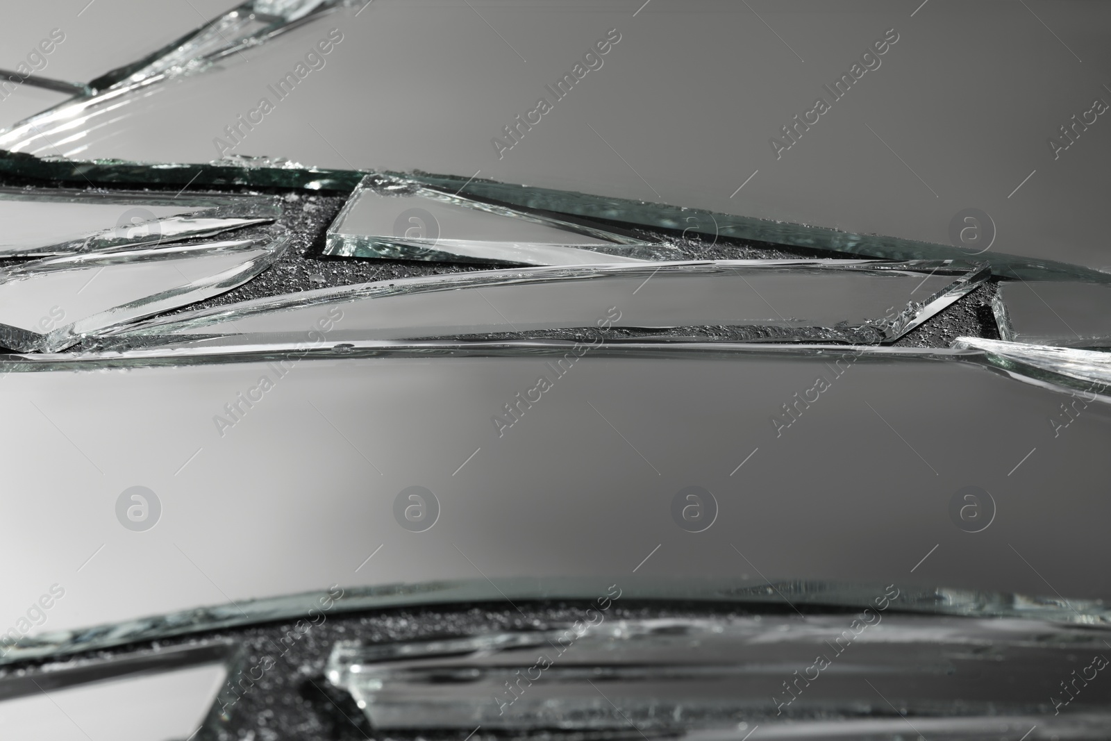 Photo of Shards of broken mirror on dark textured background, closeup