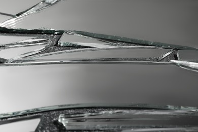 Photo of Shards of broken mirror on dark textured background, closeup