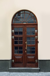 Entrance of house with beautiful arched wooden door and transom window