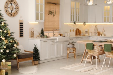 Photo of Cozy open plan kitchen decorated for Christmas. Interior design