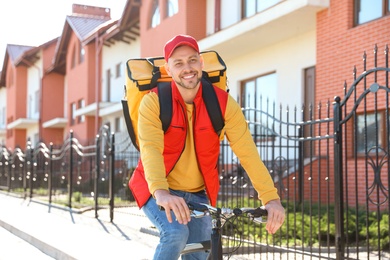 Male courier on bicycle delivering food in city