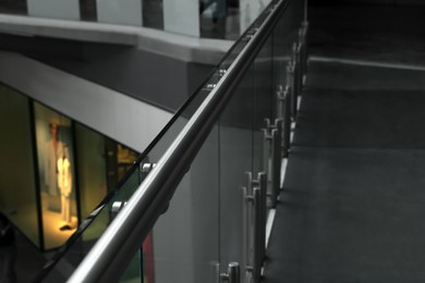 Photo of Glass barrier with metal handrail in modern building, closeup
