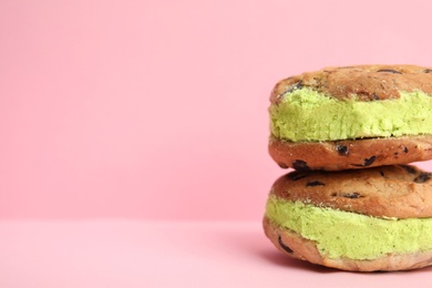 Photo of Sweet delicious ice cream cookie sandwiches on color background, space for text