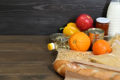 Different donation food on wooden table, closeup. Space for text