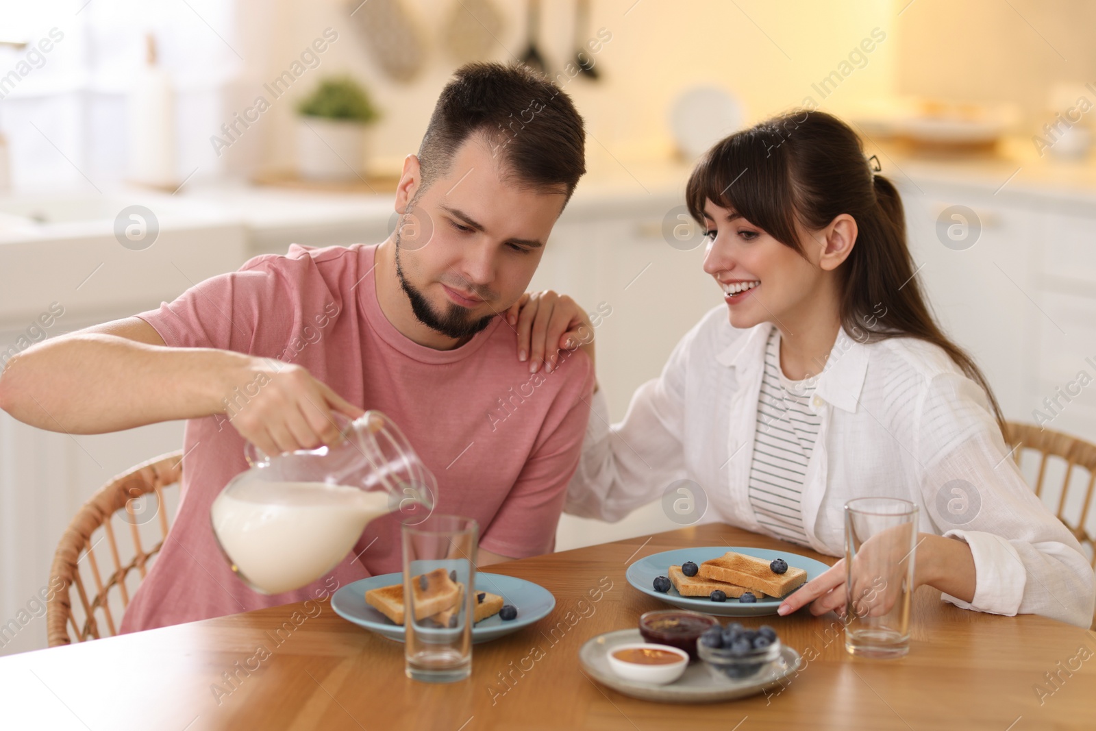 Photo of Happy couple having tasty breakfast at home