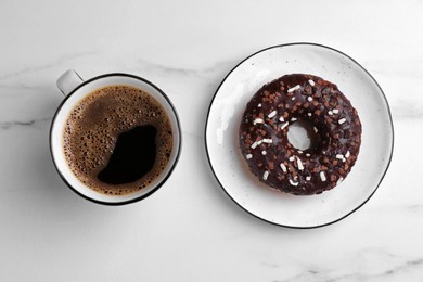 Tasty donut and cup of coffee on white marble table, flat lay