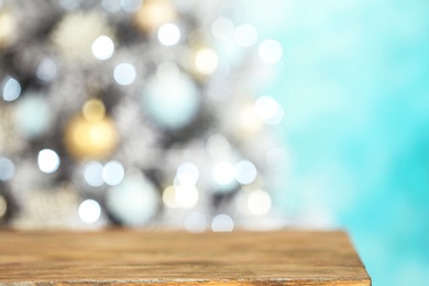 Photo of Empty wooden table and blurred fir tree with Christmas lights on background, bokeh effect. Space for design