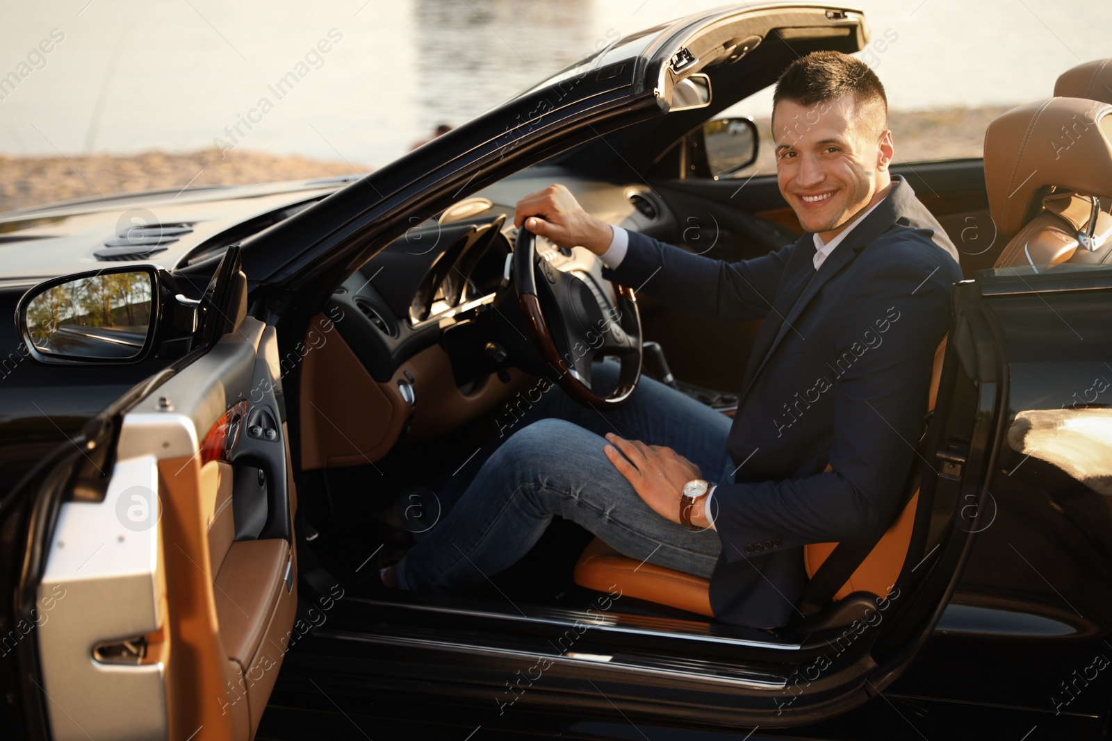 Photo of Young businessman in luxury convertible car outdoors