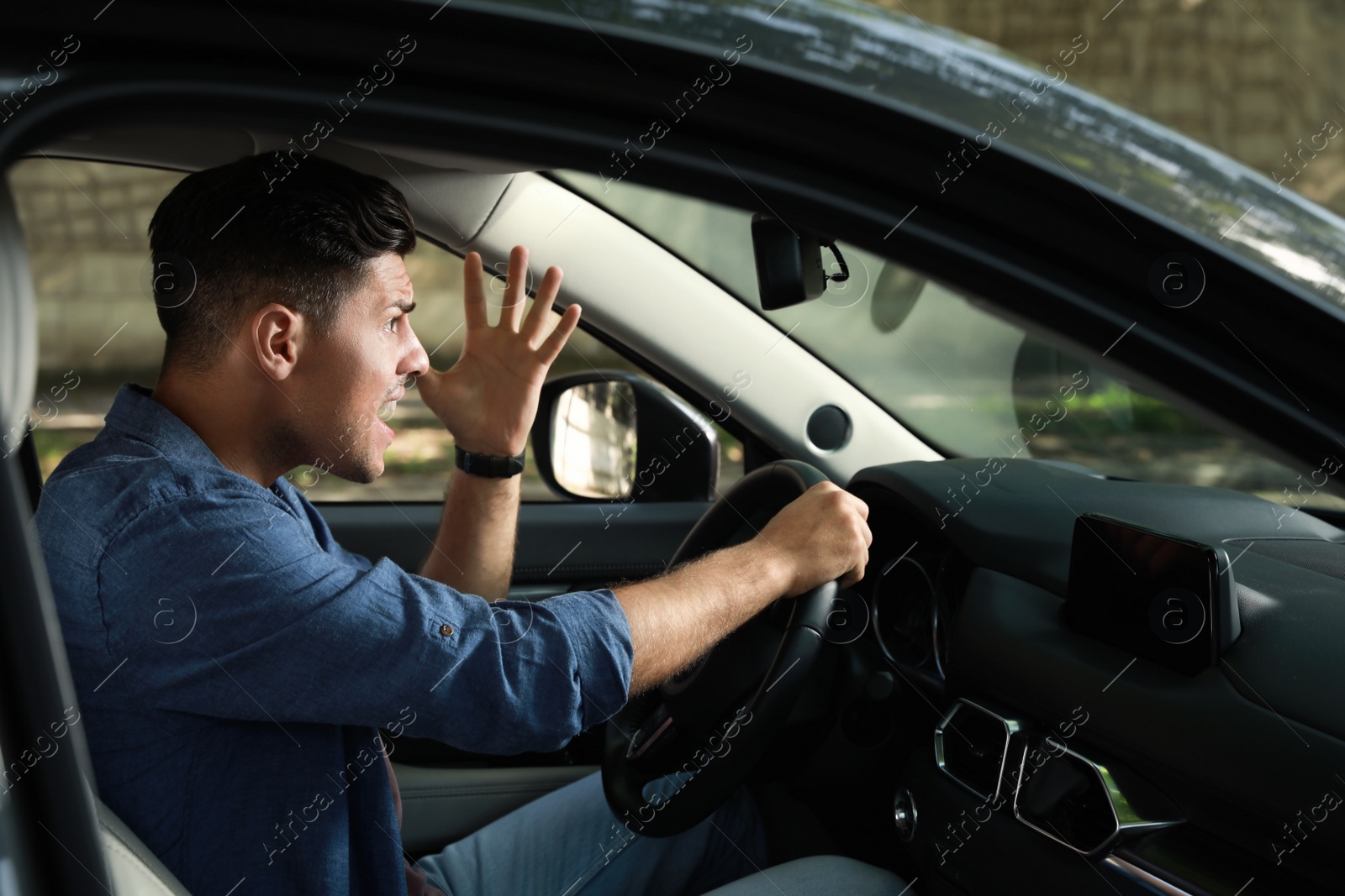 Photo of Stressed man in driver's seat of modern car