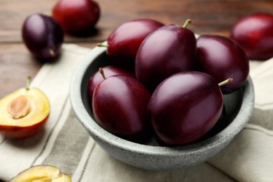 Many tasty ripe plums on table, closeup