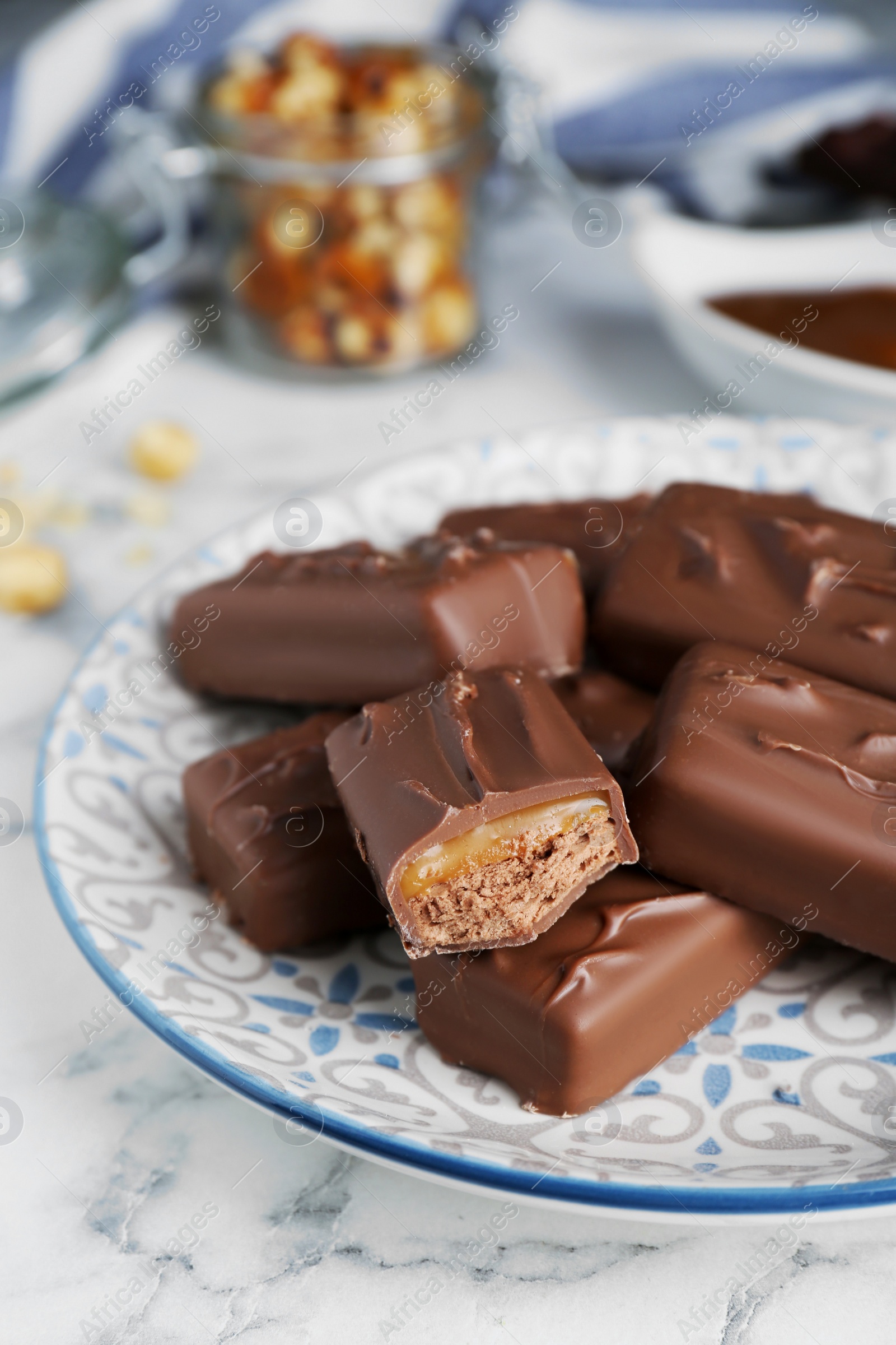 Photo of Delicious chocolate candy bars on white marble table, closeup