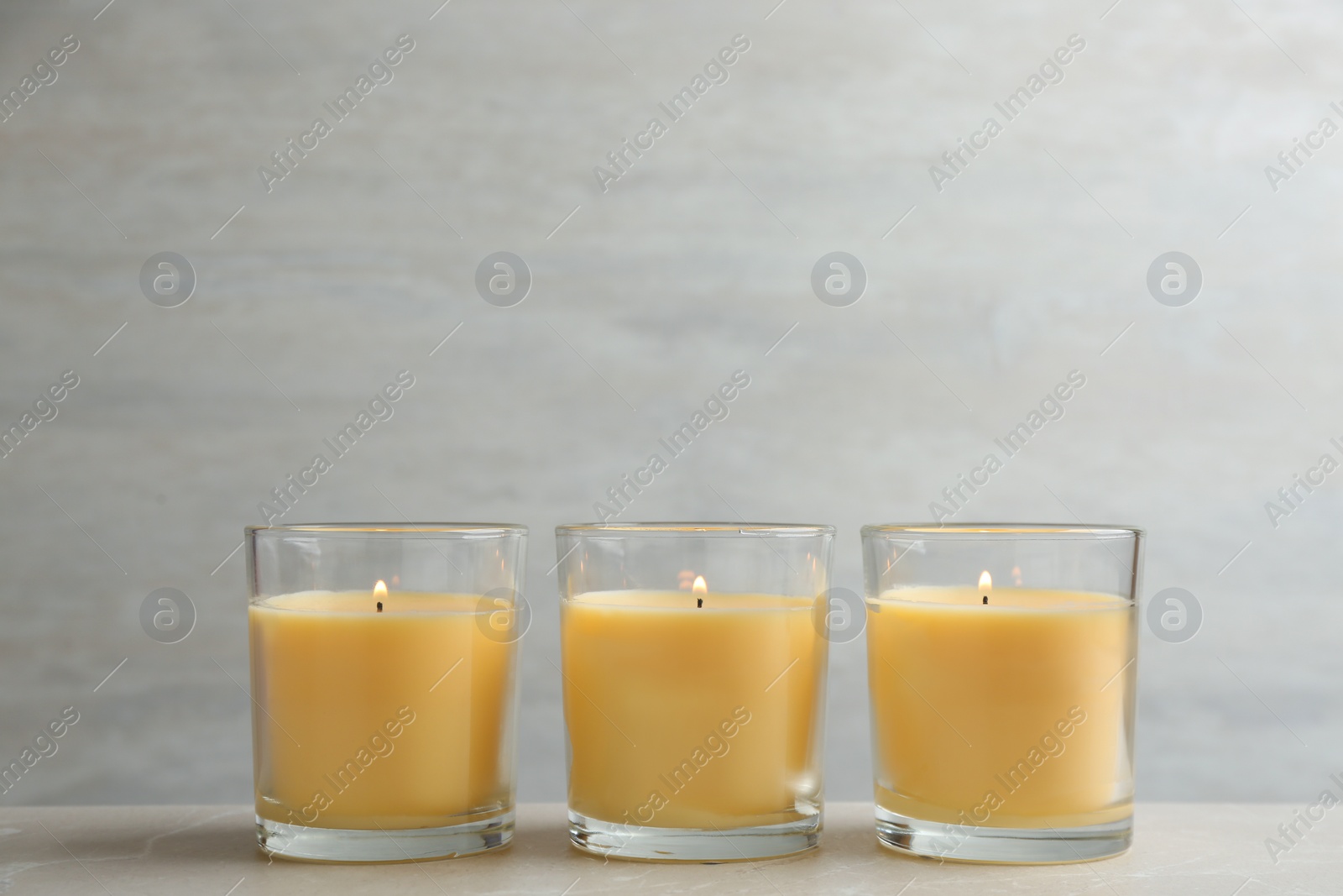 Photo of Composition with three burning candles on table. Space for text