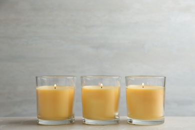 Composition with three burning candles on table. Space for text