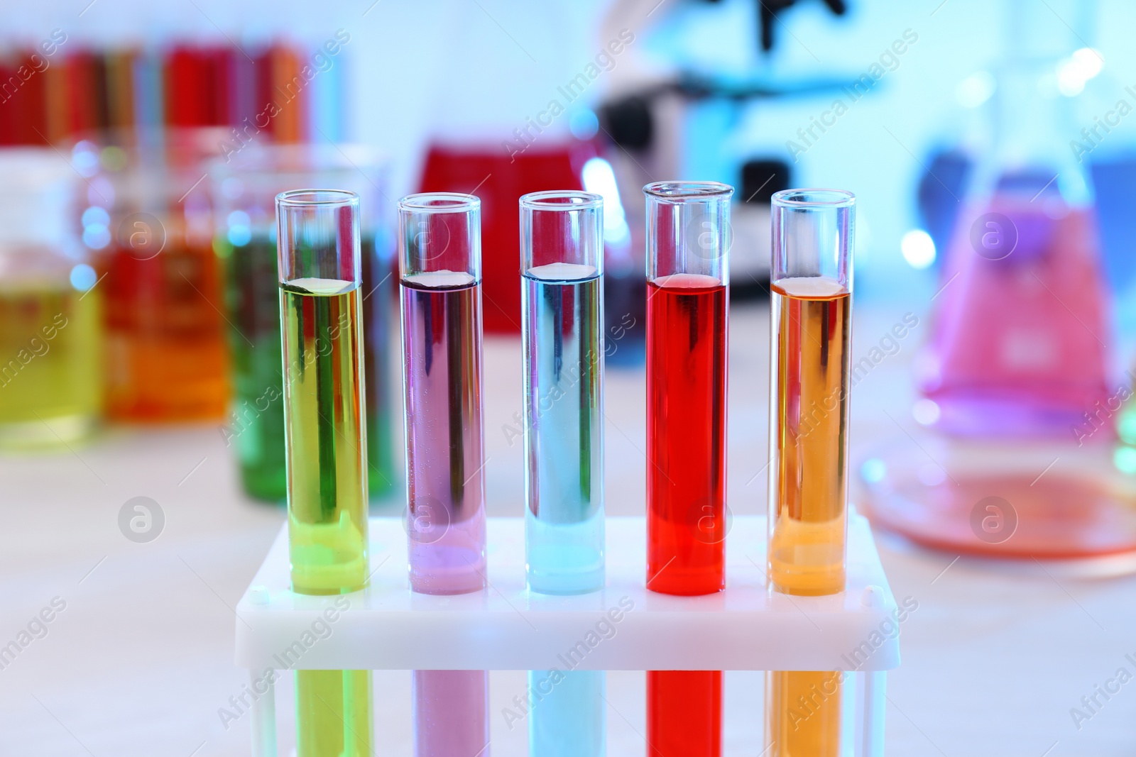 Photo of Test tubes with samples in rack on table. Solution chemistry