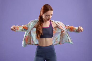 Photo of Young woman wearing sportswear on violet background